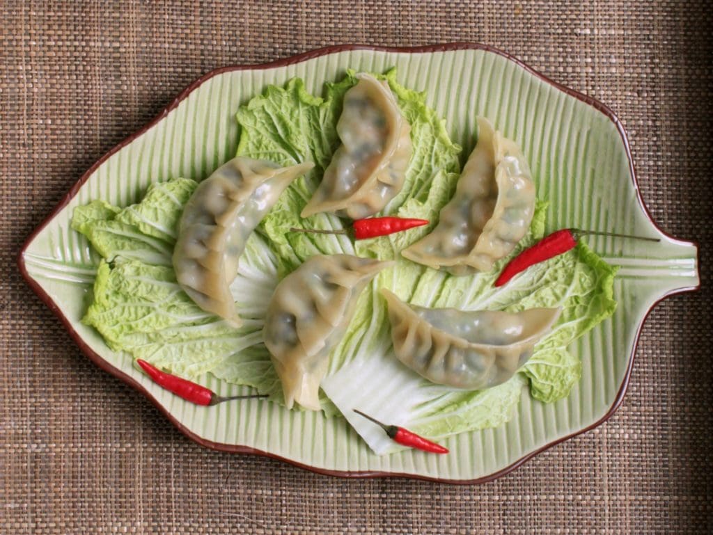 A leaf shaped plate filled with plump steamed Shrimp Lentil dumplings.