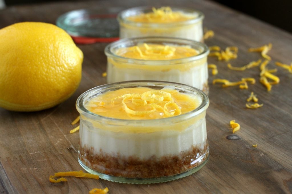 Brighten your grey day with a bit of citrus! Rich mini lemon cheesecakes topped with tangy lemon curd. #cheesecake #lemoncurd #citrus