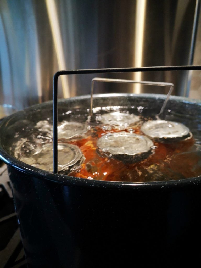 Pickled Carrots with Dill and Garlic - A large canner filled with boiling hot water and jars of pickled carrots.