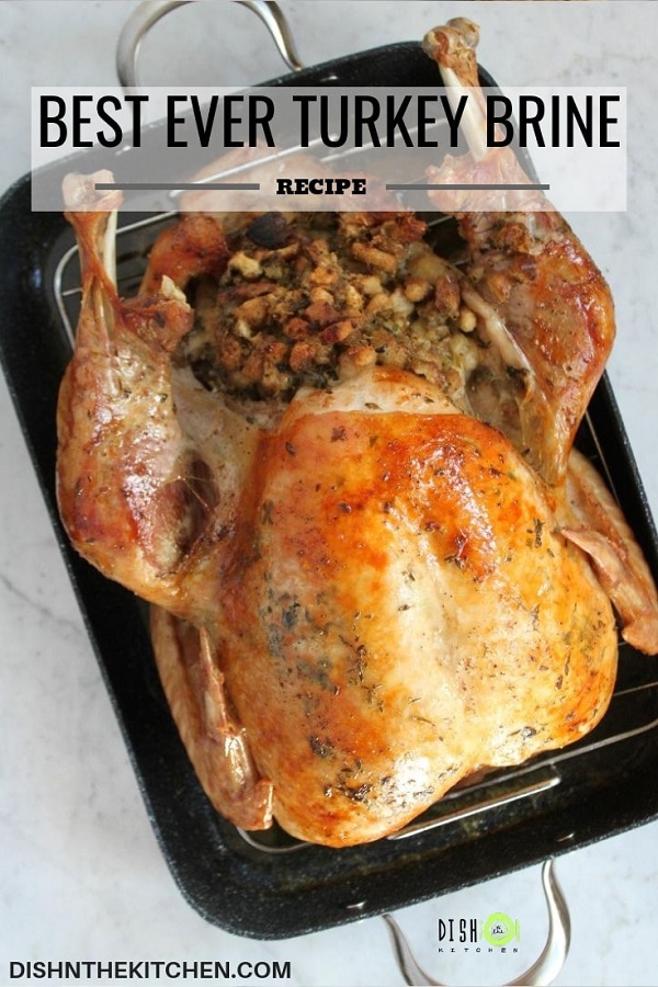 Pinterest image showing a beautiful fully cooked and stuffed in a black roasting pan.